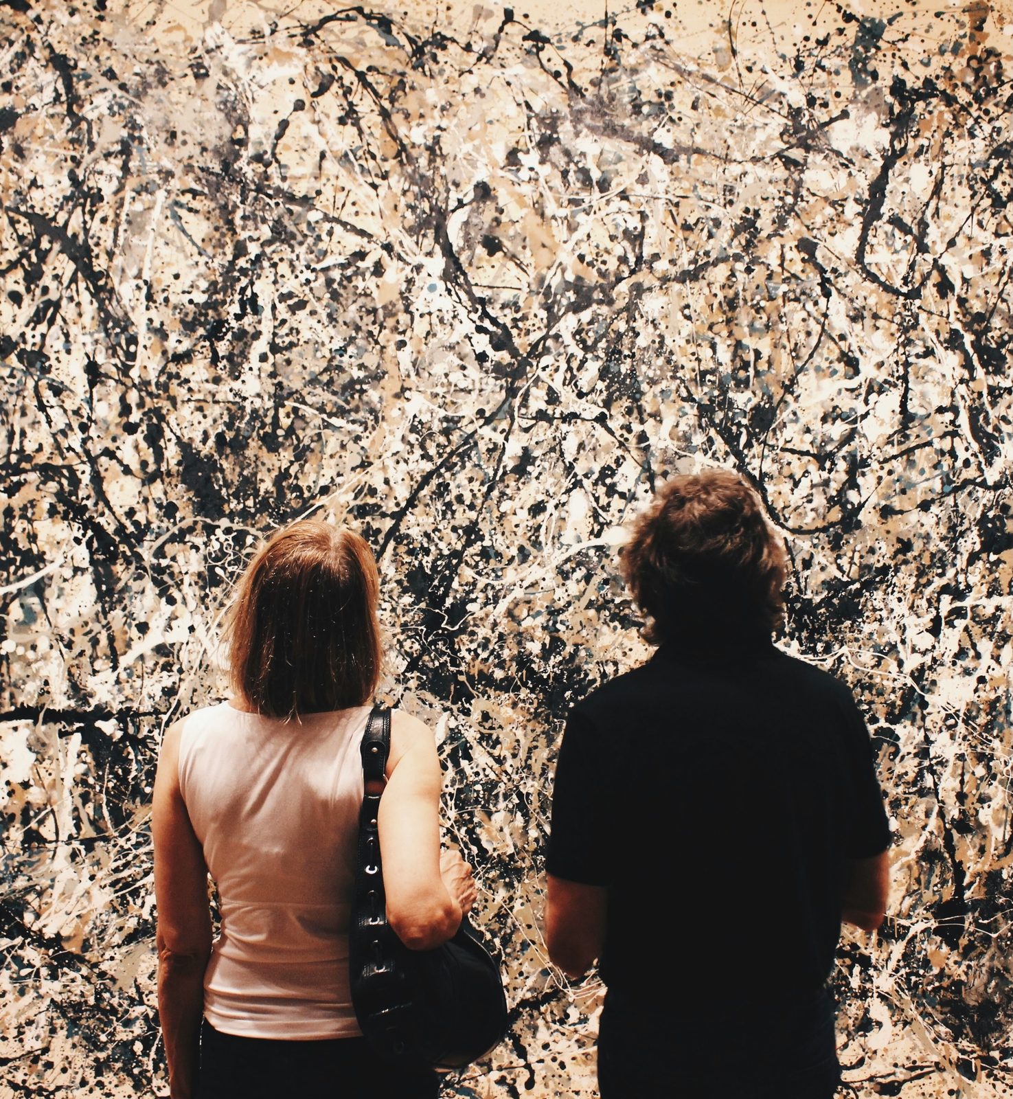 Zwei Besucher vor einem Drip Painting von Jackson Pollock
